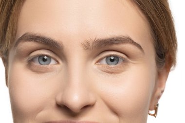 Beyaz stüdyo arka planında izole edilmiş genç kadın modelin yakın portresi. Güzel, beyaz tenli, beyaz bir kadın..