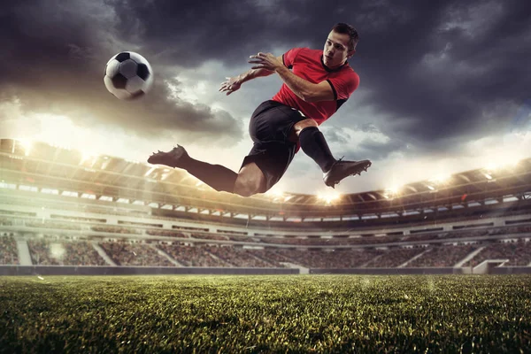 Professional male football, soccer player on stadium background. Caucasian fit athlete practicing, playing excited in flight — Stock Photo, Image