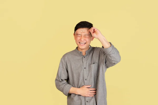 Azjatycki portret młodego mężczyzny na żółtym tle studia. Pojęcie ludzkich emocji, ekspresji twarzy, młodzieży, sprzedaży, reklamy. — Zdjęcie stockowe