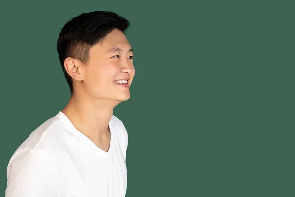 Close-up Asian young mans portrait on green studio background. Concept of human emotions, facial expression, youth, sales, ad. — Stockfoto