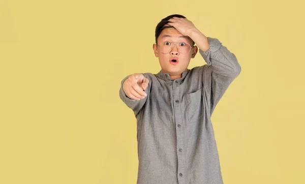 Asiático jovem homem retrato no fundo do estúdio amarelo. Conceito de emoções humanas, expressão facial, juventude, vendas, anúncio. — Fotografia de Stock