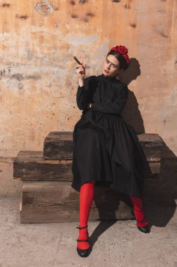 Sanat aktrisliği yapan genç bir kadın oyuncu tuğla arka plandaki en iyi resimleri yeniden yapıyor. Retro biçimi, dönemin karşılaştırması.