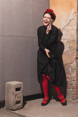 Young woman in the image of a famous artist, personality laughing isolated on vintage background. Retro style, comparison of eras concept.