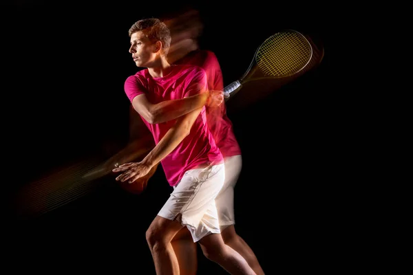 One man, male tennis player training isolated in mixed neon light on dark background. Concept of sport, team competition. — Foto Stock