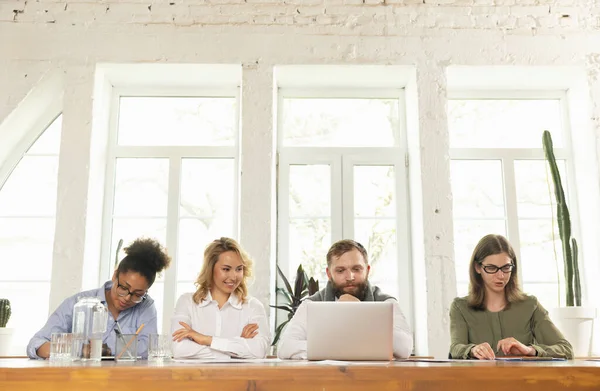 Jeunes hommes d'affaires, collègues travaillant ensemble dans un bureau moderne à l'aide d'appareils et de gadgets pendant les négociations — Photo