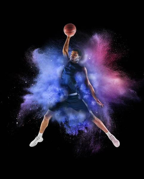 黒の背景に隔離された色のネオンパウダーの爆発で1人の若いスポーツマンバスケットボール選手 — ストック写真