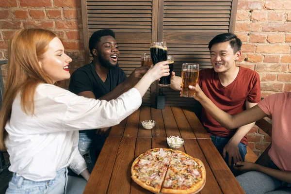 Hombres y chicas jóvenes, amigos reunidos en la cafetería, pub. Concepto de amistad, actividad de ocio, emociones, — Foto de Stock