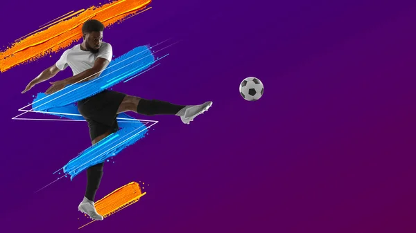 Umělecká koláž. Mladý muž, fotbalista trénink izolovaný v neonovém světle na purpurovém pozadí. Akvarelové barvy. Pojetí sportu, hry, akce. — Stock fotografie