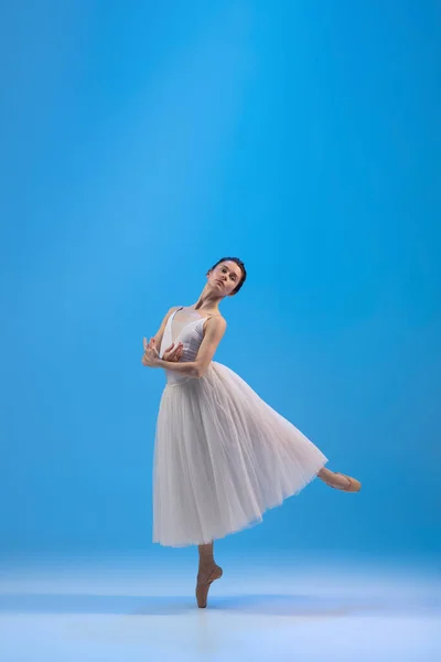年轻而美丽的芭蕾舞演员在充满阳光的蓝色工作室里表演和跳舞. — 图库照片