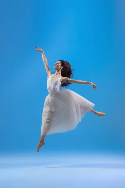 Mladý a půvabný baletní tanečník izolovaný na modrém pozadí studia. Umění, pohyb, akce, flexibilita, inspirace. — Stock fotografie