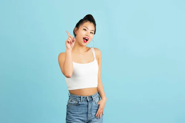 ¡Vaya! Hermoso retrato frontal femenino de media longitud aislado sobre fondo de estudio azul. Joven mujer emocional sorprendida de pie con la boca abierta. Emociones humanas, concepto de expresión facial. —  Fotos de Stock