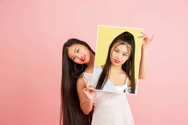 Chica joven sosteniendo su retrato aislado sobre fondo de estudio con copyspace para el anuncio. Concepto de belleza, moda. —  Fotos de Stock