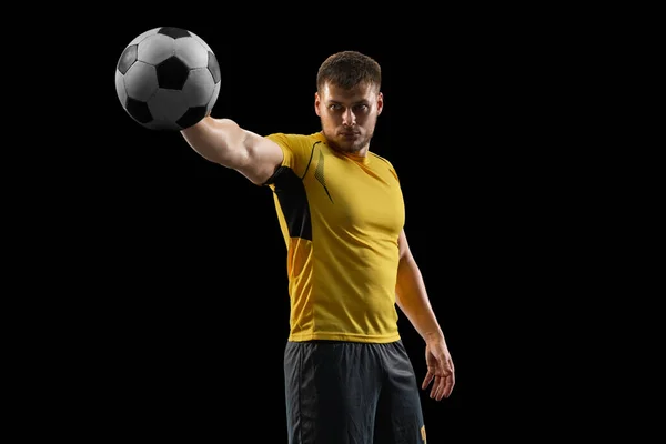Giocatore di calcio caucasico professionista in piedi isolato su sfondo nero studio. — Foto Stock