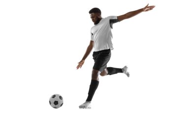Beyaz arka planda izole edilmiş bir Afrikalı futbolcu eğitimi. Spor, hareket, enerji ve dinamik kavramı.