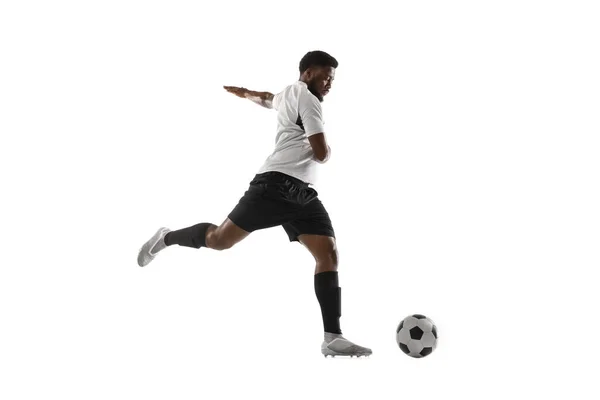 Jovem jogador de futebol africano treinando isolado em fundo branco. Conceito de esporte, movimento, energia e dinâmica. — Fotografia de Stock