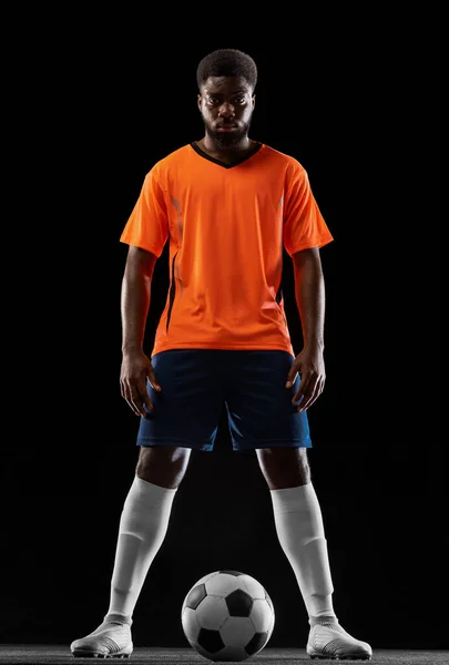 Retrato de jovem jogador de futebol africano posando isolado em fundo preto. Conceito de desporto. — Fotografia de Stock