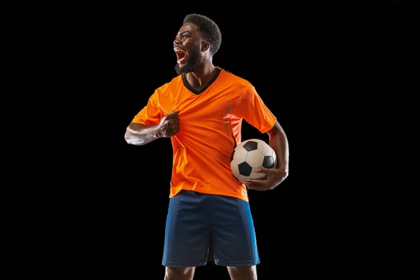 Retrato de jovem jogador de futebol africano posando isolado em fundo preto. Conceito de desporto. — Fotografia de Stock