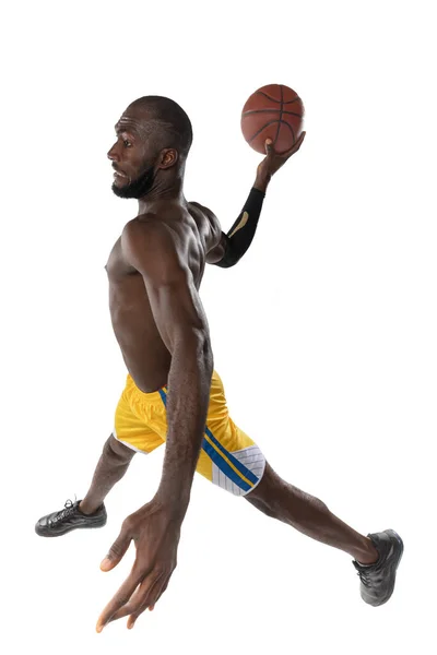 화이트 스튜디오 배경에 공 이 고립된 농구 선수의 전체 장 초상화. 광고 컨셉. 공을 타고 달리는 Fit african 미국 운동 선수. — 스톡 사진