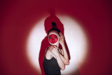 Kırmızı stüdyo arka planında dans eden balerin. Modern tasarım. Japonya 'da yükselen güneş olarak çağdaş renkli kavramsal ışık.