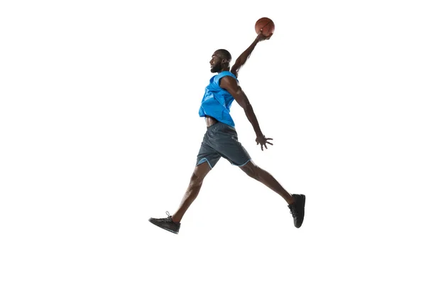 Retrato de comprimento total de um jogador de basquete com uma bola isolada no fundo do estúdio branco. conceito de publicidade. Apto atleta afro-americano pulando com bola. — Fotografia de Stock