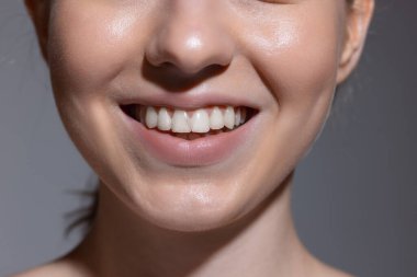 Yakın plan kesilmiş kadın yüzü gri stüdyo arka planında izole edilmiş. Güzellik kavramı, kozmetik, kaplıca.