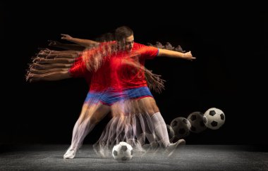 Durmadan hareket ediyor. Kafkasyalı genç futbolcu koyu arkaplanda karışık ışıkta oynuyor..