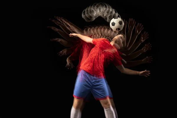 Durmadan hareket ediyor. Kafkasyalı genç futbolcu koyu arkaplanda karışık ışıkta oynuyor.. — Stok fotoğraf