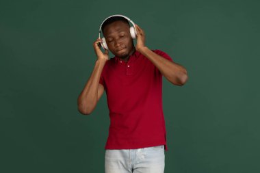 Male portrait isolated over studio background with copyspace. Listening to music