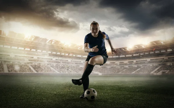 Female soccer, football player dribbling ball in motion at the stadium during sport match on cloudy sky background. Collage — ストック写真