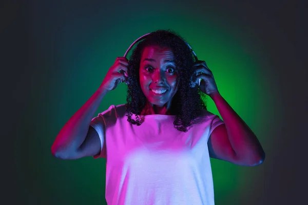 Latino jonge vrouwen portret op donkere studio achtergrond in neon. Concept van menselijke emoties, gezichtsuitdrukking. — Stockfoto