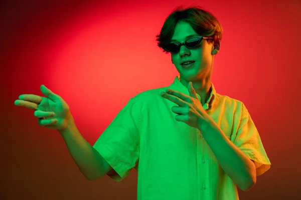 Caucasian young mans portrait on dark studio background in neon. Concept of human emotions, facial expression. — Stock Photo, Image