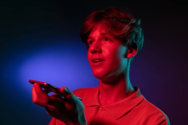 Ses mesajı kaydediliyor. Neon 'daki gradyan turuncu stüdyo arka planında modern portre.