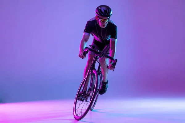 Rowerzysta jeżdżący na rowerze odizolowanym na neonowym tle — Zdjęcie stockowe