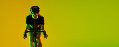 Bisikletçi, neon arka planda izole edilmiş bisiklet kullanıyor.
