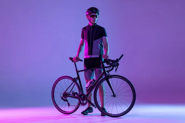 Ciclista in bicicletta isolato sullo sfondo al neon — Foto Stock