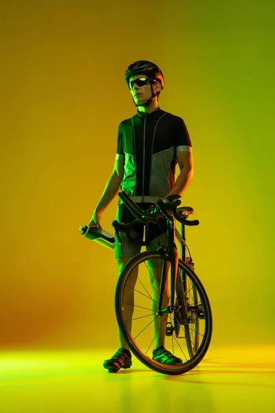 Ciclista montando uma bicicleta isolada contra fundo de néon — Fotografia de Stock