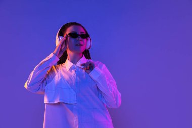 Kafkas genç kadın portresi neon renkli karanlık stüdyo arka planında. İnsan duyguları kavramı, yüz ifadesi.