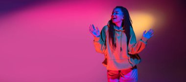 Neon renkli stüdyo arka planında genç kadın portresi. İnsan duyguları kavramı.