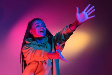 Neon renkli stüdyo arka planında genç kadın portresi. İnsan duyguları kavramı.