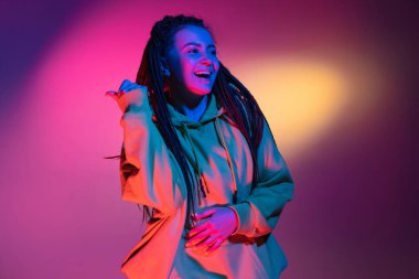 Neon renkli stüdyo arka planında genç kadın portresi. İnsan duyguları kavramı.