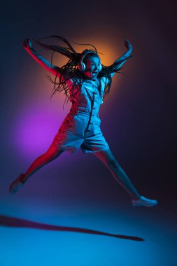 Kafkas genç kadın portresi neon renkli karanlık stüdyo arka planında. İnsan duyguları kavramı, yüz ifadesi.