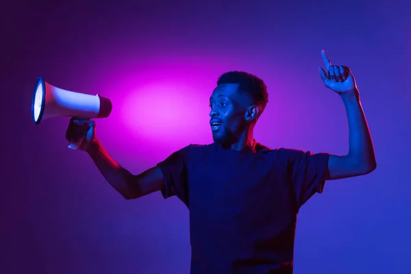 Joven africano aislado en fondo de estudio azul en neón. Concepto de emociones humanas, expresión facial. —  Fotos de Stock