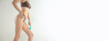 Kadınların kolları bacağının üstüne kuru fırça tutar.