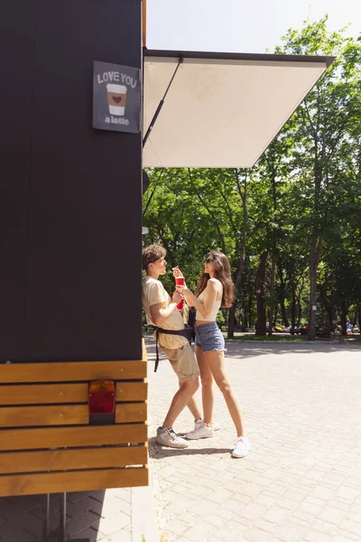 Счастливая привлекательная молодая пара романтически ест свежую пиццу на открытом воздухе. — стоковое фото