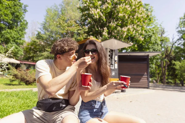Feliz atraente jovem casal romanticamente comer uma pizza fresca ao ar livre. — Fotografia de Stock