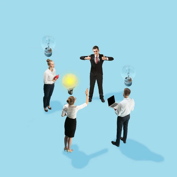 Teamwork. Junge Leute, Büroangestellte in Businesskleidung stehen isoliert auf blauem Hintergrund. — Stockfoto