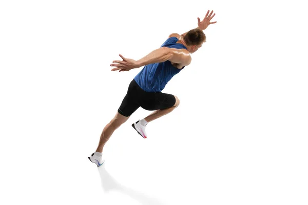 Кавказский профессиональный спортсмен, бегун тренирующийся изолированно на белом фоне студии. Мускулистый, спортивный человек. Концепция действия, движения, молодежи, здорового образа жизни. Копирование для рекламы. — стоковое фото