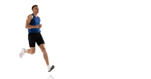 Atleta masculino profesional caucásico, entrenamiento de corredor aislado en fondo de estudio blanco. Hombre musculoso y deportivo. Concepto de acción, movimiento, juventud, estilo de vida saludable. Copyspace para anuncio. — Foto de Stock