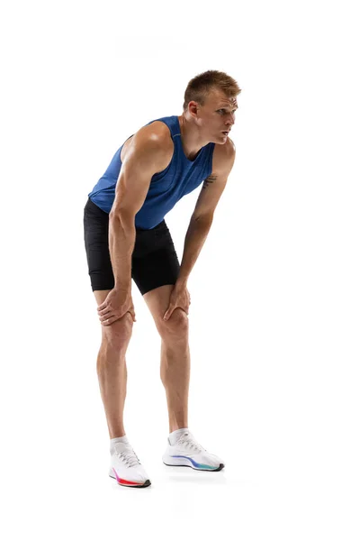 Atleta masculino profesional caucásico, corredor de pie aislado en el fondo del estudio blanco. Hombre musculoso y deportivo. — Foto de Stock