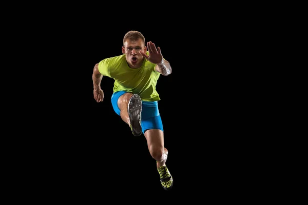 Atleta hombre atleta salta sobre la barrera aislada sobre fondo negro. —  Fotos de Stock